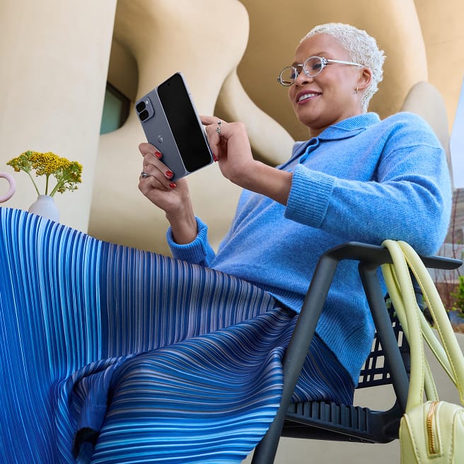 A person smiles as they use their unfolded Pixel 10 Pro Fold