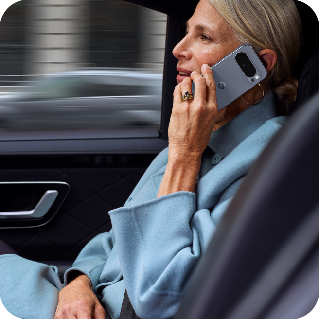 Woman working on her Google Pixel 10 Pro from her car.
